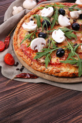 Tasty pizza with vegetables and arugula on table close up