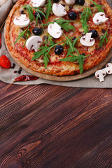 Tasty pizza with vegetables and arugula on table close up