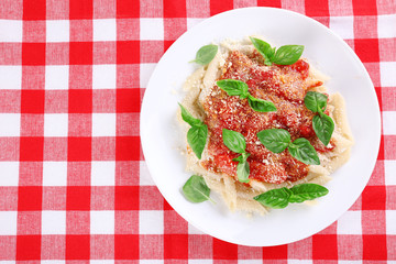 Pasta with tomato sauce and basil on table close up