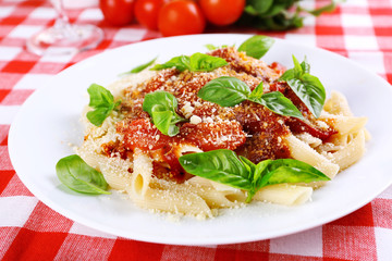 Pasta with tomato sauce and basil on table close up