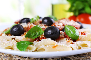 Pasta with tomato sauce and basil on table close up