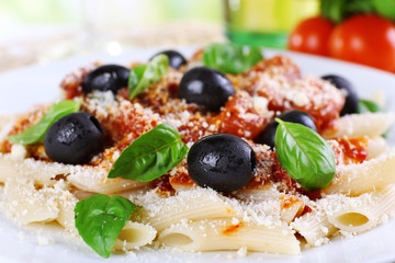 Pasta with tomato sauce and basil on table close up