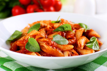 Pasta with tomato sauce and basil on table close up