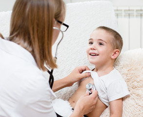 doctor examining boy with stethoscope