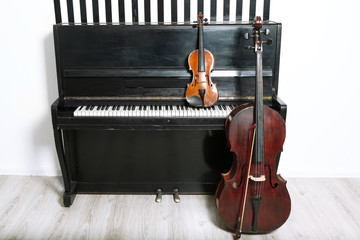 Piano, cello and violin on white wall background © Africa Studio
