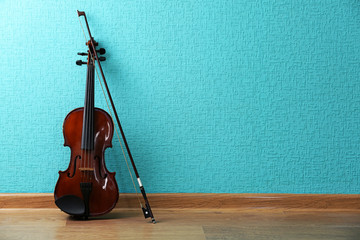 Classical violin on turquoise wallpaper background