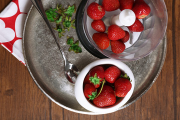 Ripe strawberries in blender on metal tray on wooden table, top view