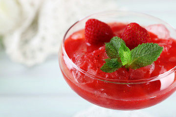Frozen Strawberry dessert in glass, on wooden table, on light background