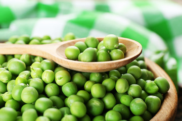 Fresh green peas in wooden bowl, closeup