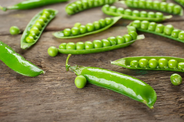 Fresh green peas on wooden background
