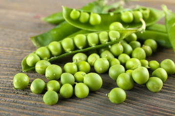 Fresh green peas on wooden table, closeup