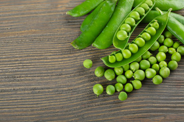 Fresh green peas on wooden table, closeup