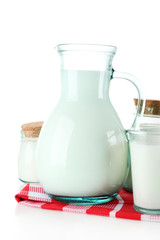 Pitcher and jars of milk on wooden table, on white background