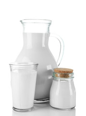 Pitcher, jar and glass of milk on wooden table, on white background