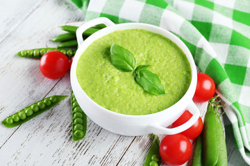 Tasty peas soup and cherry tomatoes on table close up