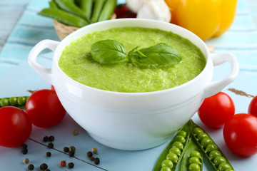 Tasty peas soup and vegetables on table close up