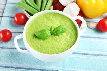 Tasty peas soup and vegetables on table close up