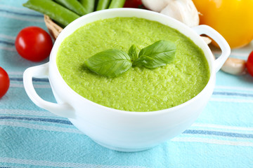 Tasty peas soup and vegetables on table close up