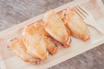 Grilled chicken wings on wooden plate