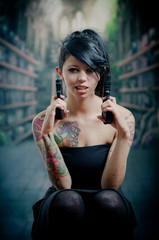 Fototapeta premium provocative tattooed girl holding gun