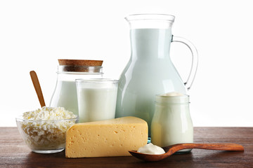 Dairy products on wooden table on white background