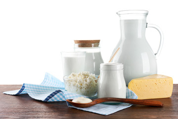 Dairy products on wooden table on white background