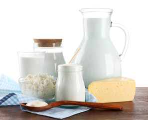 Dairy products on wooden table on white background