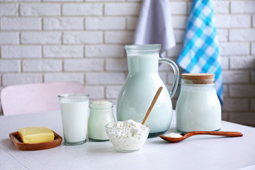 Dairy products on wooden table, on brick wall background