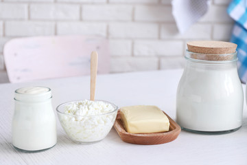 Dairy products on wooden table, on brick wall background