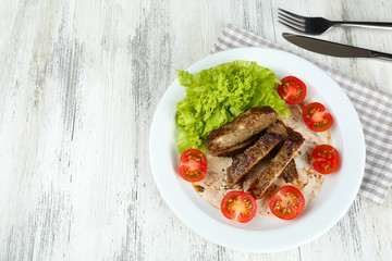 Tasty slices of meat with sauce and cherry tomato on table close up