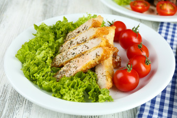 Slices of chicken fillet with spices and cherry tomato on table close up