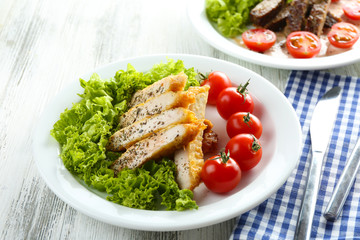 Slices of chicken fillet with spices and cherry tomato on table close up