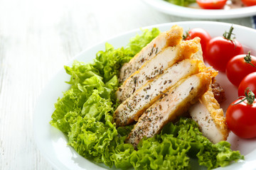 Slices of chicken fillet with spices and cherry tomato on table close up