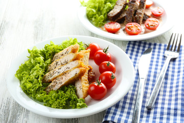 Slices of chicken fillet with spices and cherry tomato on table close up