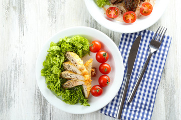 Slices of chicken fillet with spices and cherry tomato on table close up