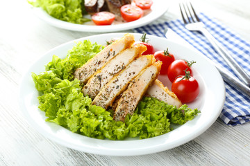 Slices of chicken fillet with spices and cherry tomato on table close up