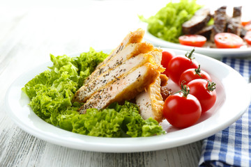 Slices of chicken fillet with spices and cherry tomato on table close up