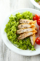 Slices of chicken fillet with spices and cherry tomato on table close up