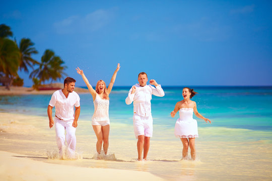 group of happy excited friends having fun on tropical beach, summer vacation