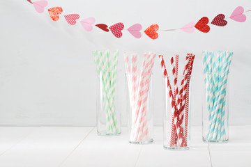 Colorful paper straws with a garland of hearts