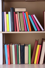 Books on wooden shelf.