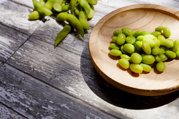 Horizontal shot of green soybeans on a wooden table
