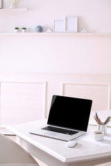 Workplace with laptop in room