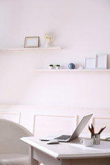 Workplace with laptop in room