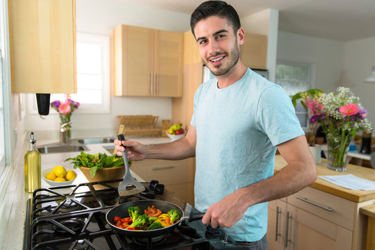 Single handsome man cooks at home alone a nutritious meal lunch dinner chef