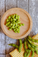 Vertical shot of green soybeans on a wooden table
