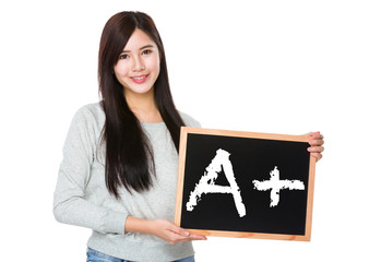 Young woman hold with chalkboard showing mark A plus