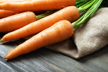 Fresh organic carrots on wooden table, closeup