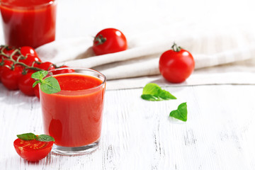 Glass of tomato juice on wooden table, closeup