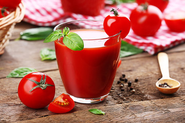 Glass of tomato juice on wooden table, closeup